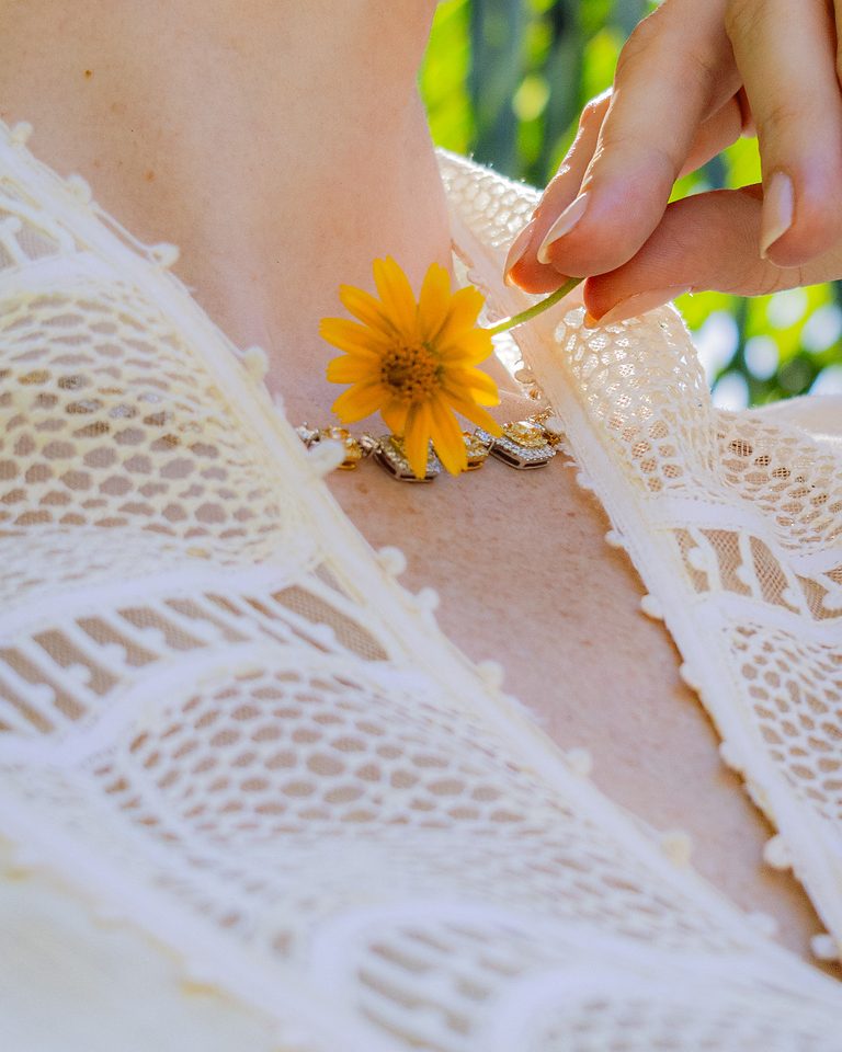 Macro da gola em renda renascença com acabamento em picô, sobre a pele.